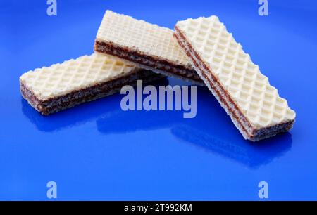 Cialda ripiena di crema al cioccolato su sfondo blu Foto Stock