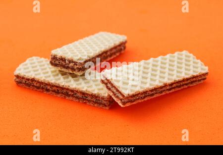 Wafer ripieno con crema al cioccolato su sfondo arancione Foto Stock