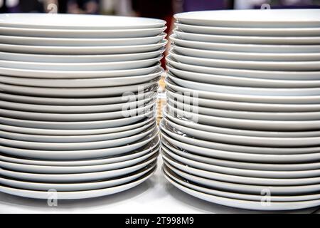 Pila di piatti bianchi su uno scaffale di un negozio o di un ristorante. Foto Stock
