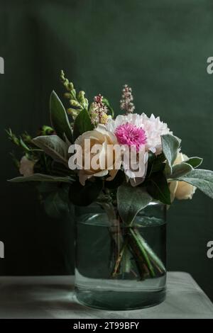 Bellissimo bouquet di fiori diversi in vaso, isolato su sfondo verde scuro, messa a fuoco selettiva, bouquet vintage Foto Stock