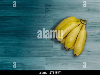 Banane mature su uno sfondo di legno turchese in Brasile Foto Stock