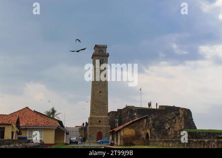 Uccelli che sorvolano la vecchia torre dell'orologio presso il forte olandese di Galle nel XVII secolo. Castello olandese in rovina, patrimonio dell'umanità dell'UNESCO a Sri Lank Foto Stock