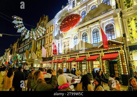 Londra, Regno Unito. 23 novembre 2023. Gli acquirenti scattano foto all'esterno del negozio Cartier. La folla di visitatori ammira le esposizioni dei negozi natalizi in New Bond Street e Old Bond Street, che presentano anche luci festive ispirate ai Gioielli della Corona. Credito: Fotografia dell'undicesima ora/Alamy Live News Foto Stock