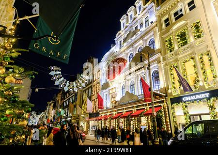 Londra, Regno Unito. 23 novembre 2023. Gli acquirenti scattano foto all'esterno del negozio Cartier. La folla di visitatori ammira le esposizioni dei negozi natalizi in New Bond Street e Old Bond Street, che presentano anche luci festive ispirate ai Gioielli della Corona. Credito: Fotografia dell'undicesima ora/Alamy Live News Foto Stock