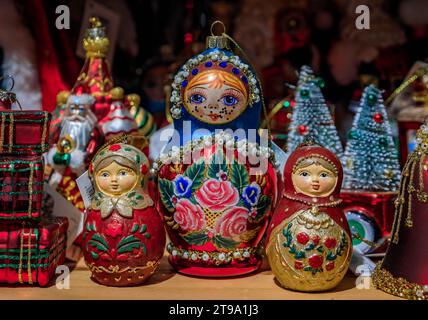 Colmar, Francia - 5 giugno 2023: Coloratissimi ornamenti natalizi e bambole russe tradizionali che nidificano matryoshka in vendita, un negozio di souvenir nella città vecchia Foto Stock