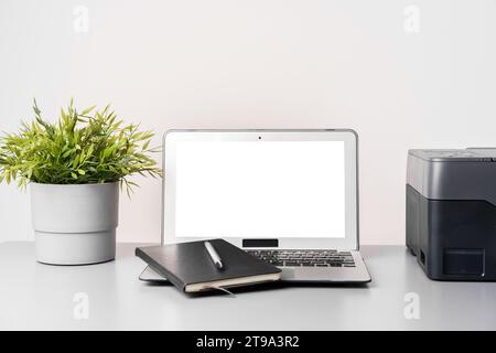 Stampante e laptop su un tavolo grigio in ufficio Foto Stock