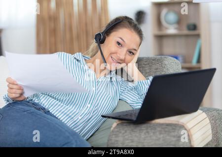 un interprete felice in cuffia traduce e scrive appunti da casa Foto Stock