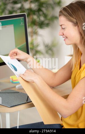 felice imprenditore che mette il documento in una busta Foto Stock