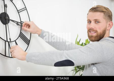 vista posteriore dell'uomo che imposta le mani di un orologio Foto Stock