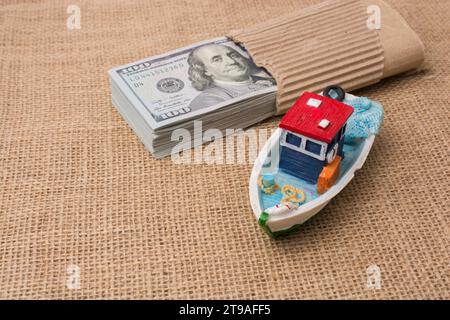 Modello barca e bundle di banconote di dollari su tela Foto Stock