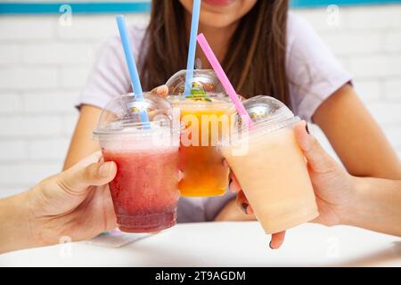 Amici che bevono insieme bibite fruttate e succulente. Foto Stock