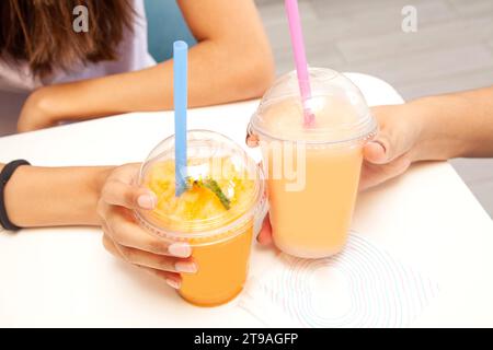 Amici che bevono insieme bibite fruttate e succulente. Foto Stock