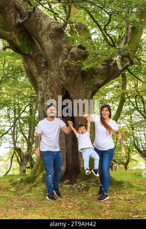 Foto verticale di una famiglia giocosa che trascorre del tempo in una foresta insieme Foto Stock