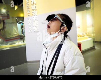 PECHINO, CINA - 24 NOVEMBRE 2023 - Un bambino visita una mostra attraverso occhiali intelligenti AR presso il Museo Nazionale di storia naturale di Pechino, Cina Foto Stock