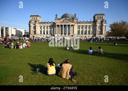 Berlino, Germania - 30 ottobre 2022: La gente si rilassa sul gras vicino al Bundestag tedesco (edificio del Reichstag) è il parlamento nazionale della federazione Foto Stock