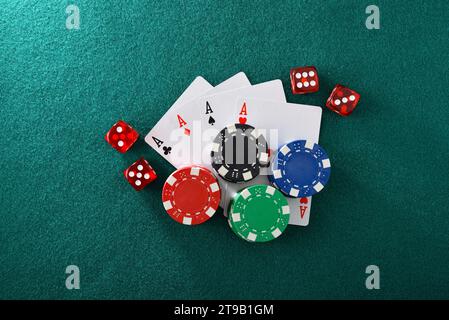 Sfondo con carte patatine e dadi per giocare al gioco d'azzardo da casinò su feltro verde e sfondo isolato verde. Vista dall'alto. Foto Stock