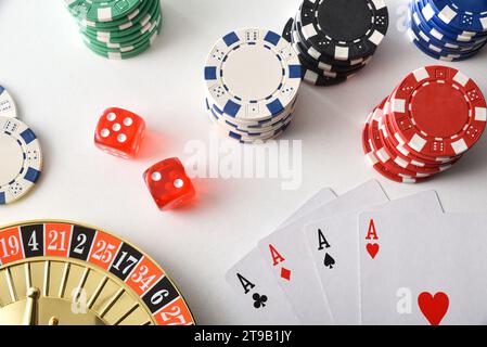 Lo sfondo dei giochi del casinò è isolato su un tavolo bianco con carte da gioco, fiches e dadi per giocare a vari giochi d'azzardo. Vista dall'alto. Foto Stock