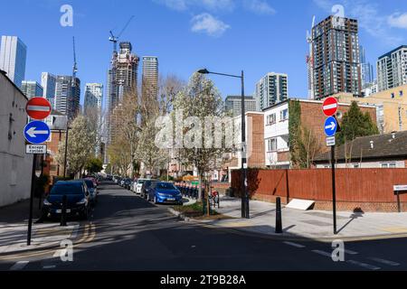 La casa sociale di Alpha Grove si trova in contrasto con i torreggianti grattacieli di Canary Wharf in costruzione sullo sfondo. Alpha Grove, Foto Stock