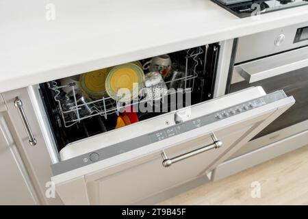 La porta della lavastoviglie si apre nella moderna cucina. Pulire i piatti lavati all'interno Foto Stock