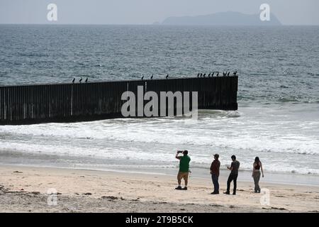 San Diego, CA, Stati Uniti - 30 luglio 2023: Turisti vicino al muro di confine USA Messico nel Border Field State Park Beach. Foto Stock