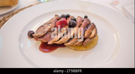 Filetti di controfiletto iberico cotti con frutta autunnale. Piatto servito su tappetino in rattan Foto Stock