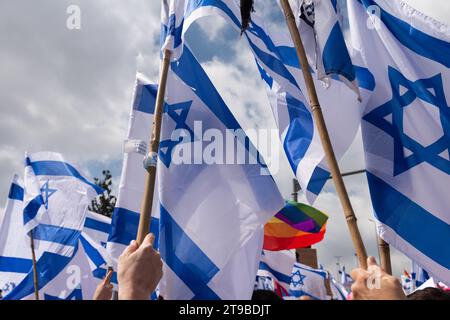 Un manifestante onda una bandiera rosa dello Stato di Israele, simbolo delle proteste anti-governative tenute in tutto Israele in opposizione alla riforma giudiziaria. Foto Stock