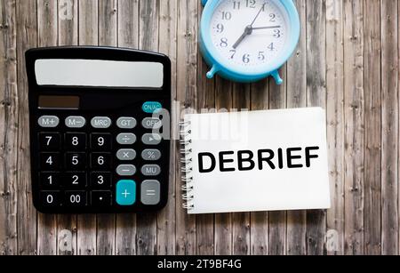 Scrivete la parola in un blocco note su uno sfondo di legno con una calcolatrice. riepilogo del concetto Foto Stock