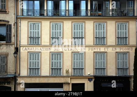 Vecchio modello di tende e finestre con il nome della vecchia compagnia dipinta o Advert idraulico in Place du Verdun città vecchia Aix-en-Provence, Francia Foto Stock