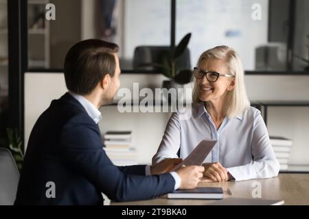 Due partner d'affari felici che parlano al tavolo della riunione Foto Stock