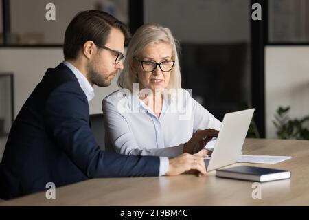 Professionista aziendale senior concentrato che si lamenta di un notebook Foto Stock