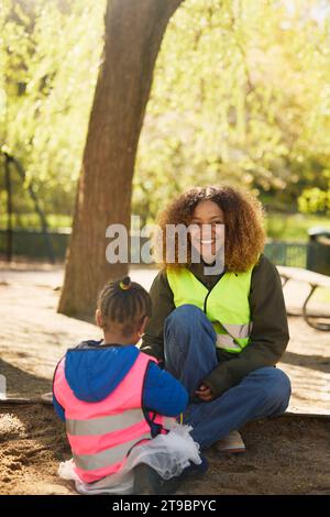 Volontario che gioca con una ragazza nel parco Foto Stock