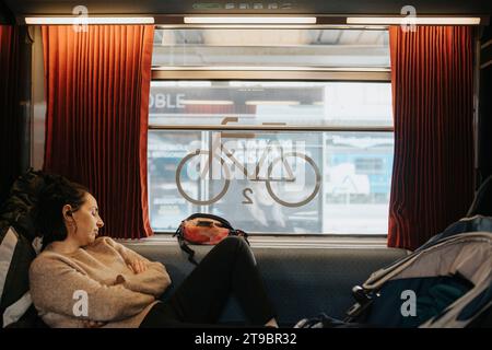 Giovane donna che dorme in treno Foto Stock