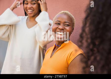 Una giovane donna che rideva mentre parlava con amici femminili Foto Stock