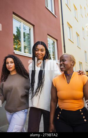 Giovani donne multirazziali che camminano in un edificio mentre passavano il fine settimana Foto Stock