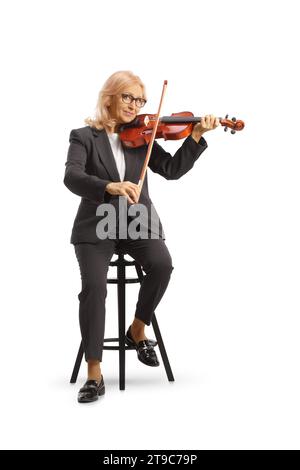 Ripresa completa di una donna seduta su una sedia e che si esibisce con un violino isolato su sfondo bianco Foto Stock