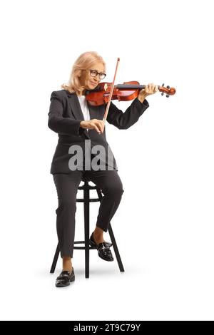 Foto completa di una donna matura seduta su una sedia e che suona un violino isolato su sfondo bianco Foto Stock