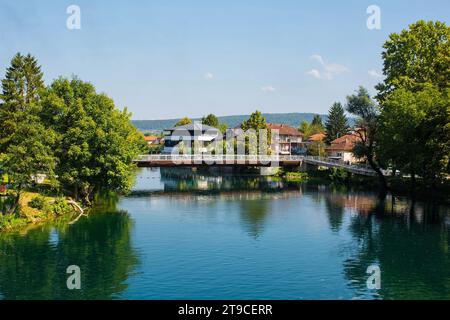 Smaragdni la maggior parte del ponte che attraversa il fiume una mentre passa attraverso il Bihac centrale nel Canton una-sana, Federazione della Bosnia ed Erzegovina Foto Stock