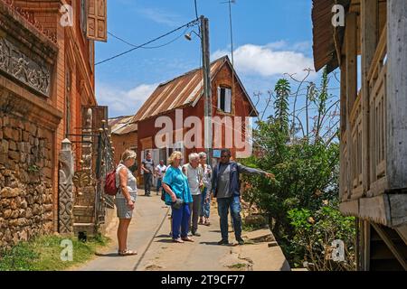 Guida malgascia con turisti europei che visitano Ambohimanga, insediamento reale fortificato / rova vicino Antananarivo, Madagascar, Africa Foto Stock