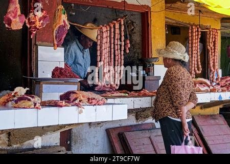 Macellaio malgascio che vende carne e salsicce presso un burchery nella città di Ambatolampy, regione di Vakinankaratra, Highlands centrali, Madagascar, Africa Foto Stock