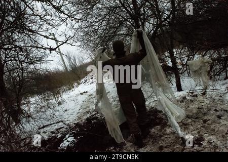 Kupyansk, Oblast' di Charkiv, Ucraina. 24 novembre 2023. Avvolgendo un mortaio in un velo di tenda, un soldato protegge un mortaio dall'osservazione dei droni russi. I soldati ucraini della 57a Brigata motorizzata separata sparano un mortaio da 120 mm contro le forze russe a 4-5 km di distanza. (Immagine di credito: © Madeleine Kelly/ZUMA Press Wire) SOLO USO EDITORIALE! Non per USO commerciale! Crediti: ZUMA Press, Inc./Alamy Live News Foto Stock