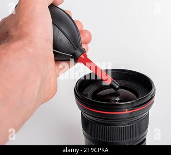 Soffiatore di polvere in mano per la pulizia dell'obiettivo della telecamera, la rimozione della polvere Foto Stock