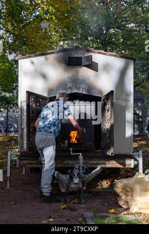 Uomo che gestisce il fuoco mobile della sauna del fumo a Helsinki, Finlandia Foto Stock