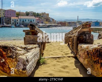 Una vista da uno scalo di barche di legno attraverso il porto di Chania, Creta in una luminosa giornata di sole Foto Stock