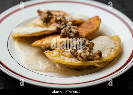 Pierogi di zucca vegana con salsa di vino cremosa e contorno di salvia di noci Foto Stock