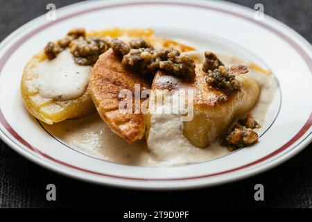 Pierogi di zucca vegana con salsa di vino cremosa e contorno di salvia di noci Foto Stock