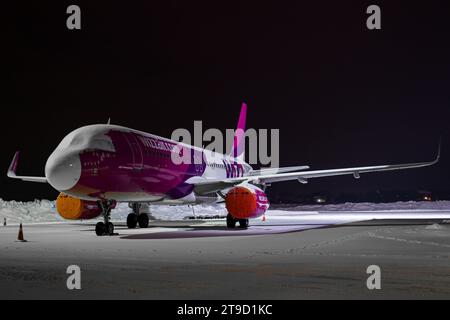 Wizzair Airbus A320 parcheggiato al cancello di Leopoli, coperto di neve, foto notturna Foto Stock