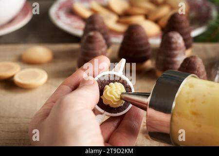 Alveari volanti o nidi di vespa, biscotti di Natale cechi tradizionali senza cottura, con crema di eggnog, utilizzando un ugello Foto Stock