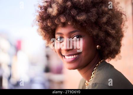 Allegro ritratto di una giovane donna africana che guarda la fotocamera sorridente. Foto Stock
