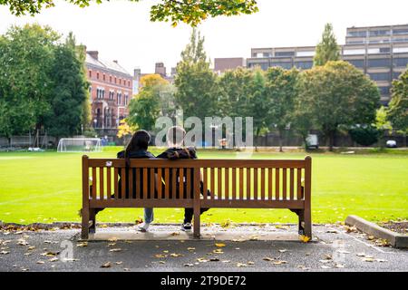 Una coppia di fronte al College Park, nel campus del Trinity College, nel centro di Dublino, Irlanda, con i turisti in una giornata di sole Foto Stock