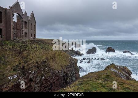 Le rovine del castello di Slains di fronte all'assalto di Storm Debi mentre le onde si infrangono sulle rocce sottostanti, Aberdeenshire, Scozia, Regno Unito Foto Stock